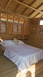 a large white bed in a room with wooden ceilings at Pachingo Tatacoa Desert in Pachingo +38 photos