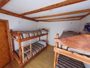 - une chambre avec 2 lits superposés et du parquet dans l'établissement Jardín de Rosas Hostel, à El Bolsón