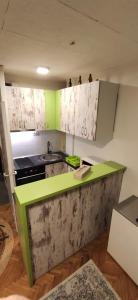 a kitchen with a green and white counter top at 3pko City center apartment in Banja Luka
