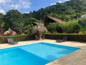 a swimming pool in front of a resort at Hotel Zaku Reserva Natural in Palomino