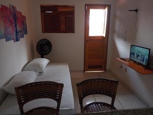 een slaapkamer met een bed en 2 stoelen en een raam bij Casa do Mochileiro Airport Hostel in São Gonçalo do Amarante