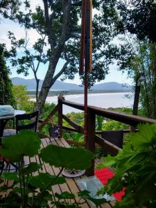 a wooden deck with a table and a view of the water at Hostel do Morro in Florianópolis