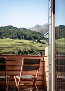 a wooden bench sitting in front of a lush green field at die berge lifestyle-hotel sölden in Sölden