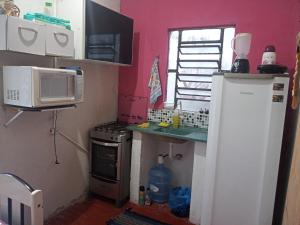 a small kitchen with a refrigerator and a microwave at Casa amora olinda in Olinda