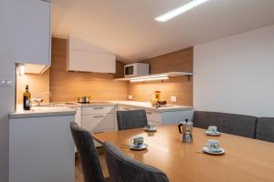 a kitchen with a table and chairs in a room at Apartments UDERA in Selva di Val Gardena