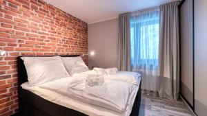 1 dormitorio con pared de ladrillo y 1 cama con toallas en Apartamenty ROYAL APARTS VIP Widok 800 - z panoramą gór, en Szklarska Poręba