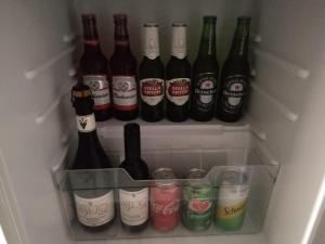 a refrigerator filled with lots of bottles of alcohol at Desejo Motel in Araçoiaba da Serra +39 photos