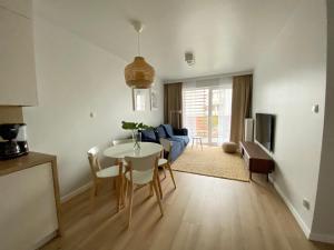 a kitchen and living room with a table and chairs at Urokliwy apartament HAVEN nad morzem+free parking in Kołobrzeg