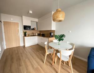 a kitchen and dining room with a table and chairs at Urokliwy apartament HAVEN nad morzem+free parking in Kołobrzeg