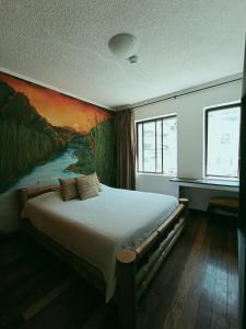 - une chambre avec un grand lit orné d'une peinture murale dans l'établissement Suites+Arte, à Quito