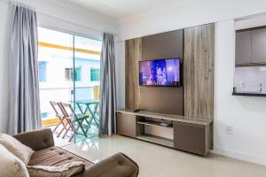 un soggiorno con divano e TV a schermo piatto di Eco Village Park a Bombinhas