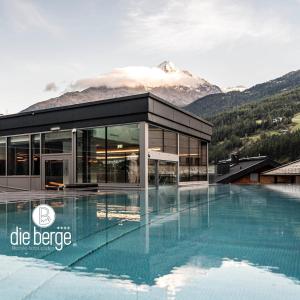 a building with a pool in front of a mountain at die berge lifestyle-hotel Sölden in Sölden