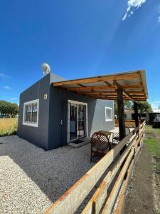 een klein huisje met een tafel en een houten dak bij india del mar in La Estafeta