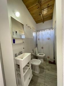 een witte badkamer met een toilet en een wastafel bij india del mar in La Estafeta