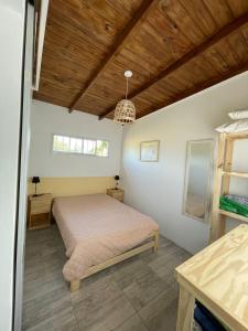 een slaapkamer met een bed en een houten plafond bij india del mar in La Estafeta