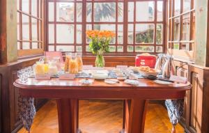a table with food and a vase of flowers on it at Boutique Hotel Casona 1914 Old Town Quito in Quito