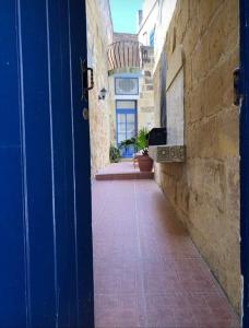 an open blue door in an alley with a building at Ta lucia farmhouse with private pool and BBQ in Santa Luċija