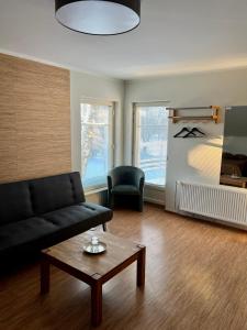 a living room with a black couch and a coffee table at Hostel Ingeri in Viljandi