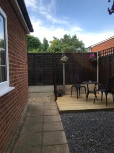 a patio with two chairs and a table and a fence at Studio-1-Staines/Heathrow/London-own entrance in Staines