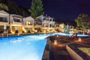 a villa with a swimming pool at night at Blue Green Bay in Panormos Skopelos