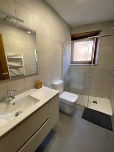 a bathroom with a sink and a toilet and a mirror at Dúplex amb altell de luxe + parking (Taüll) in Taüll