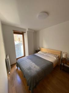 a bedroom with a bed and a window at Dúplex amb altell de luxe + parking (Taüll) in Taull