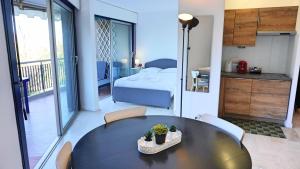 a room with a table and a bedroom with a bed at Résidence Islette du Riou avec piscine By Palmazur in Mandelieu-la-Napoule