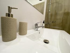 La salle de bains est pourvue d'un lavabo, d'un robinet et d'un miroir. dans l'établissement El Patio 79, à Lisbonne