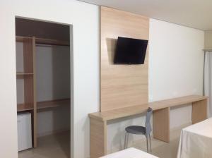 a room with a desk and a tv on a wall at Itumbiara Palace Hotel in Itumbiara