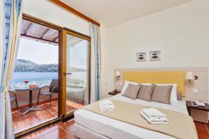 a bedroom with a bed and a view of the ocean at Blue Green Bay in Panormos Skopelos