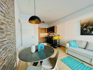 ein Wohnzimmer mit einem Tisch und einem Sofa in der Unterkunft TrIIIple Level 20 - Sonnenwohnen Apartment mit Parkplatz und fantastischem Ausblick in Wien