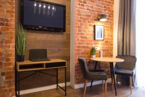 a room with a table and a tv on a brick wall at Excellent apartment in the Center – Alchevskyh str. 23 in Kharkiv