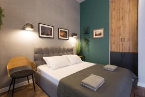 a small bedroom with a bed and a chair at Excellent apartment in the Center – Alchevskyh str. 23 in Kharkiv