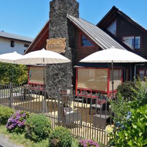 プコンにあるB&B HMüllerの建物の前にあるレストラン(テーブルと傘付)