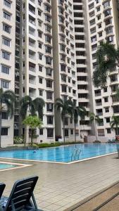 a swimming pool in front of a large apartment building at CASA TROPICANA - 2-Room CONDO with facilities in Petaling Jaya