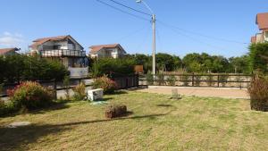 a yard with a fence and a house at Agradable Casa en Condominio Prados del Mar Tongoy in Tongoy
