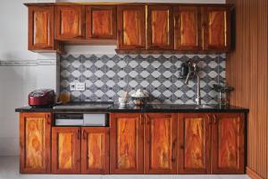 a kitchen with wooden cabinets and a counter top at Căn Hộ 3 PN Rin's House in Phan Thiet