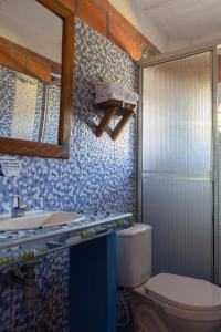 bagno con servizi igienici, lavandino e specchio di Hotel Luna Llena a San Sebastián de Mariquita