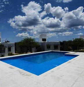 una grande piscina blu di fronte a un edificio di La Catalina Traslasierra a Nono