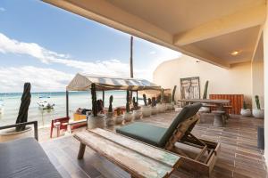 a patio with a table and chairs and the ocean at Ocean Plaza by Zamá Homes in Playa del Carmen