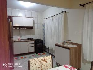 a kitchen with white cabinets and a counter top at Apartamento em Bombinhas in Bombinhas