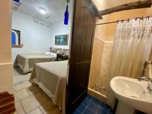 a room with a bed and a sink and a bathroom at Hotel Boutique Casa José in Cobán