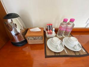 een tafel met een koffiezetapparaat en 2 flessen water bij Phnom Penh Le Vincent Hotel in Phnom Penh