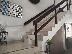 a staircase in a living room with a clock on the wall at Hostal Yoha in Panama City