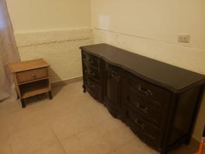 a black dresser and a stool in a room at Casa de campo by the river in Estelí
