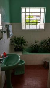 bagno con lavandino verde e vasca di Casarão das Figueiras a Caxias do Sul