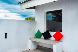 dwie kolorowe poduszki siedzące na ławce w domu w obiekcie Eden Studio Apartments - 2 w mieście Ja-Ela