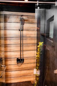 a shower in a room with a wooden wall at Eden Studio Apartments - 2 in Ja-Ela