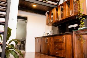 a kitchen with wooden cabinets and a sink at Eden Studio Apartments - 2 in Ja-Ela