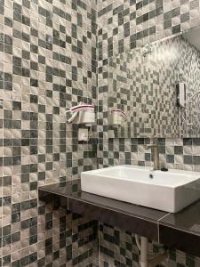 a bathroom with a sink and a tiled wall at YipStay in Gopeng